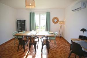uma sala de jantar com uma mesa de madeira e cadeiras em La maison verd'O Sisteron em Sisteron