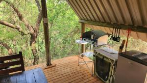 an outside view of a kitchen on a deck at Jackal Cry River View Tent in Skeerpoort