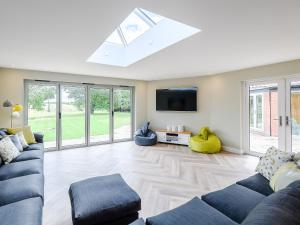 a living room with a couch and a tv at Cherry Ridge in Great Bircham