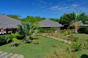 un giardino con palme e un resort di ANJARA LODGE Villa de 3 chambres a Nosy Be