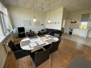- un salon avec une table et des chaises dans l'établissement Skærven Beachfront Apartments and Cottage, à Nyborg