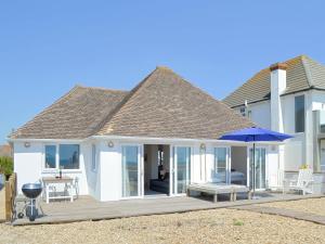 a house with a deck with an umbrella at Salty Lodge in South Hayling