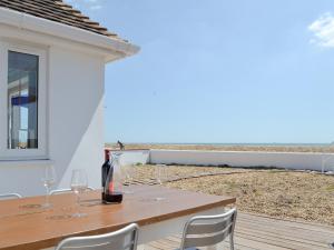 a wooden table with wine glasses on a balcony at Salty Lodge in South Hayling