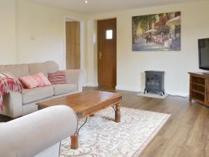 a living room with a couch and a coffee table at The Lodge in Wedmore