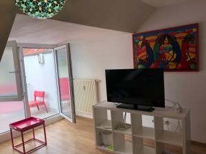 a living room with a flat screen tv on a table at Studio Ochsenfurt mit sonnigem Balkon in Ochsenfurt