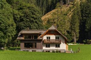 dom pośrodku pola w obiekcie Alpenrose Boutique Chalet Gretl w mieście Ramsau am Dachstein