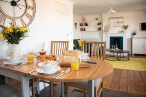 uma mesa de madeira com comida numa sala de estar em Bright, Seaview Apartment, Beachfront, 3 bedrooms, 2 bathrooms, kid & dog friendly at The Lookout Broadstairs em Broadstairs