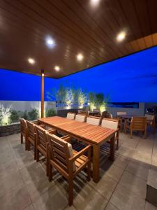 - une table et des chaises en bois sur une terrasse la nuit dans l'établissement CozyNest - Modern 1 Bedroom Gem Luxury Smart Unit, à Ángeles