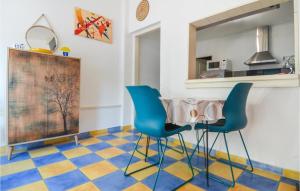 a kitchen with two blue chairs and a checkered floor at 1 Bedroom Beautiful Home In Mouris in Mouriès