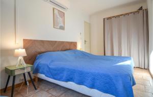 a bedroom with a blue bed and a table and a lamp at 1 Bedroom Beautiful Home In Mouris in Mouriès