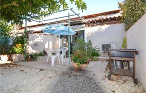 d'une terrasse avec une table, un parasol et un piano. dans l'établissement 1 Bedroom Beautiful Home In Mouris, à Mouriès