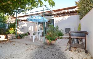 een patio met een tafel, een parasol en een piano bij 1 Bedroom Beautiful Home In Mouris in Mouriès