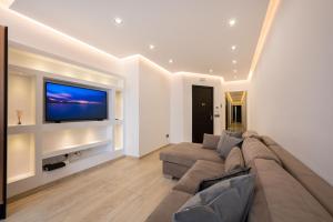 een woonkamer met een bank en een flatscreen-tv bij Stylish 2 bedroomed apartment Gzira (UPDATED PICS) in Il-Gżira
