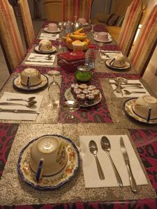 貝代的住宿－Les Chambres Du Rochereuil，上面有盘子和银器的桌子