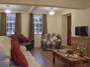 a living room with a couch and a chair at Brookside Cottage in Forton