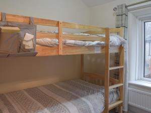 two bunk beds in a room with a bed at Brookside Cottage in Forton