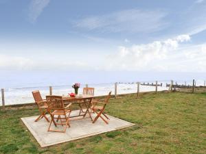 a table and chairs sitting on the grass near the beach at Sea Drift in Walcott