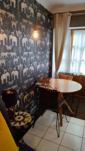 a dining room with a table and a patterned wall at Daiches Braes Brunstane Portobello in Edinburgh