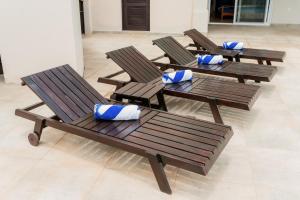 4 drewniane krzesła z niebieskimi poduszkami w pokoju w obiekcie Seaside Serenity at Casa Cala Azul home w mieście San Juan del Sur