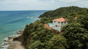 a house on a cliff next to the ocean at Seaside Serenity at Casa Cala Azul home in San Juan del Sur