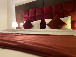 um quarto com uma cama grande e uma cabeceira vermelha em ايزي للوحدات المخدومة em Abḩur al Janūbīyah