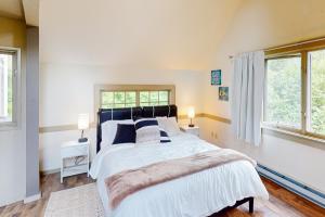 a bedroom with a large bed and two windows at Potter Place in Eugene