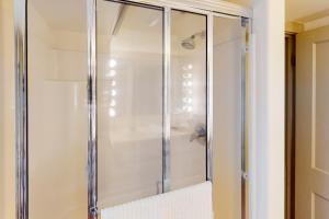 a shower with glass doors in a bathroom at Potter Place in Eugene