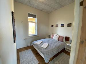 a small bedroom with a bed and a window at Skærven Beachfront Apartments and Cottage in Nyborg