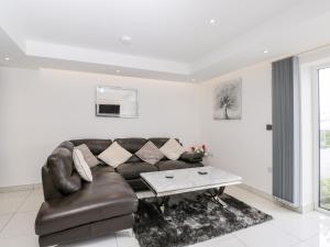 uma sala de estar com um sofá de couro e uma mesa de centro em The Penthouse, Strawberry Hill Vineyard em Newent