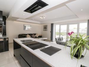 an open kitchen and living room with a couch at The Penthouse, Strawberry Hill Vineyard in Newent