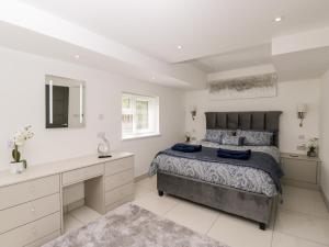 ein Schlafzimmer mit einem großen Bett und einem Schreibtisch in der Unterkunft The Penthouse, Strawberry Hill Vineyard in Newent