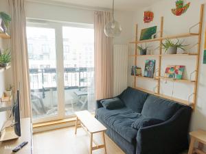 - un salon avec un canapé bleu en face d'une fenêtre dans l'établissement Apartament Mokotów/Taśmowa 6, à Varsovie