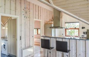- une cuisine avec des murs en bois et un comptoir avec des chaises dans l'établissement Beautiful Home In Skjern With Wifi, à Stavning