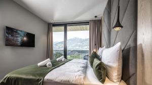 a bedroom with a bed with a large window at Panorama Eagle Lodge in Hart im Zillertal