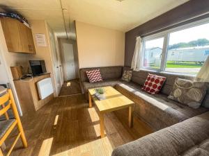 a living room with a couch and a table at 8 Berth Caravan At Broadland Sands Holiday Park In Suffolk Ref 20140bs in Hopton on Sea