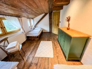 an attic room with a green cabinet and a window at Hamerská chaloupka in Hlinsko