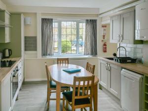 a kitchen with a table and chairs and a window at Ivy-w40854 in Llanddona