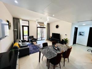a living room with a table and a couch at one bedroom Modern Apartment Muscat Bay in Muscat