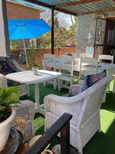 a patio with a table and chairs and a blue umbrella at 57 On Wellington Accommodation in Colchester