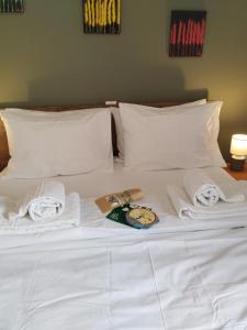 a white bed with towels and a book on it at ISLAND TIME in Chios