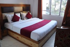 a bedroom with a large bed with red pillows at Hotel Tourist Home By palak Hospitality in Mussoorie