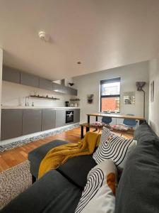 a living room with a couch and a kitchen at Luxury Townhouse, Manchester Sleeps 6 in Manchester