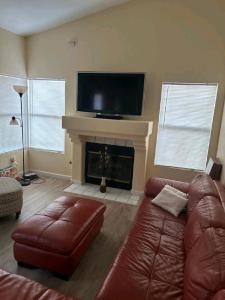 sala de estar con sofá y chimenea en Be Our Guest-Shared Home Tampa, en Palmdale