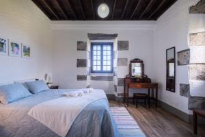 a bedroom with a bed and a table and a window at Ocean View - Nordeste in Feteira Grande