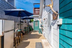 an alley with a blue building and an umbrella at The Blue Parrot Guest House in Ocean Beach