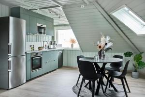 a kitchen with blue cabinets and a table with chairs at Hatty's Habitat By Staysville in Stavanger