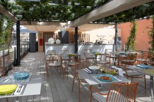 un patio avec tables et chaises sur un toit dans l'établissement Catalonia Eixample 1864, à Barcelone 40 autres photos