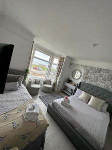 a bedroom with two beds and a window at The Beach House in Lowestoft