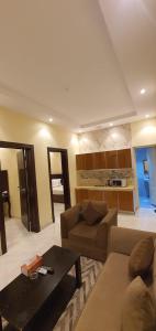 een woonkamer met een bank en een tafel bij درة الراشد للشقق المخدومة in Hafr Al Baten