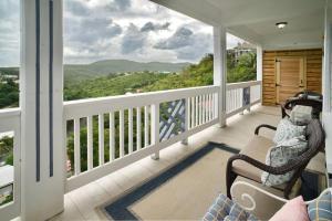 a balcony with a chair and a view of the mountains at Scotland Villa 2 in St Thomas